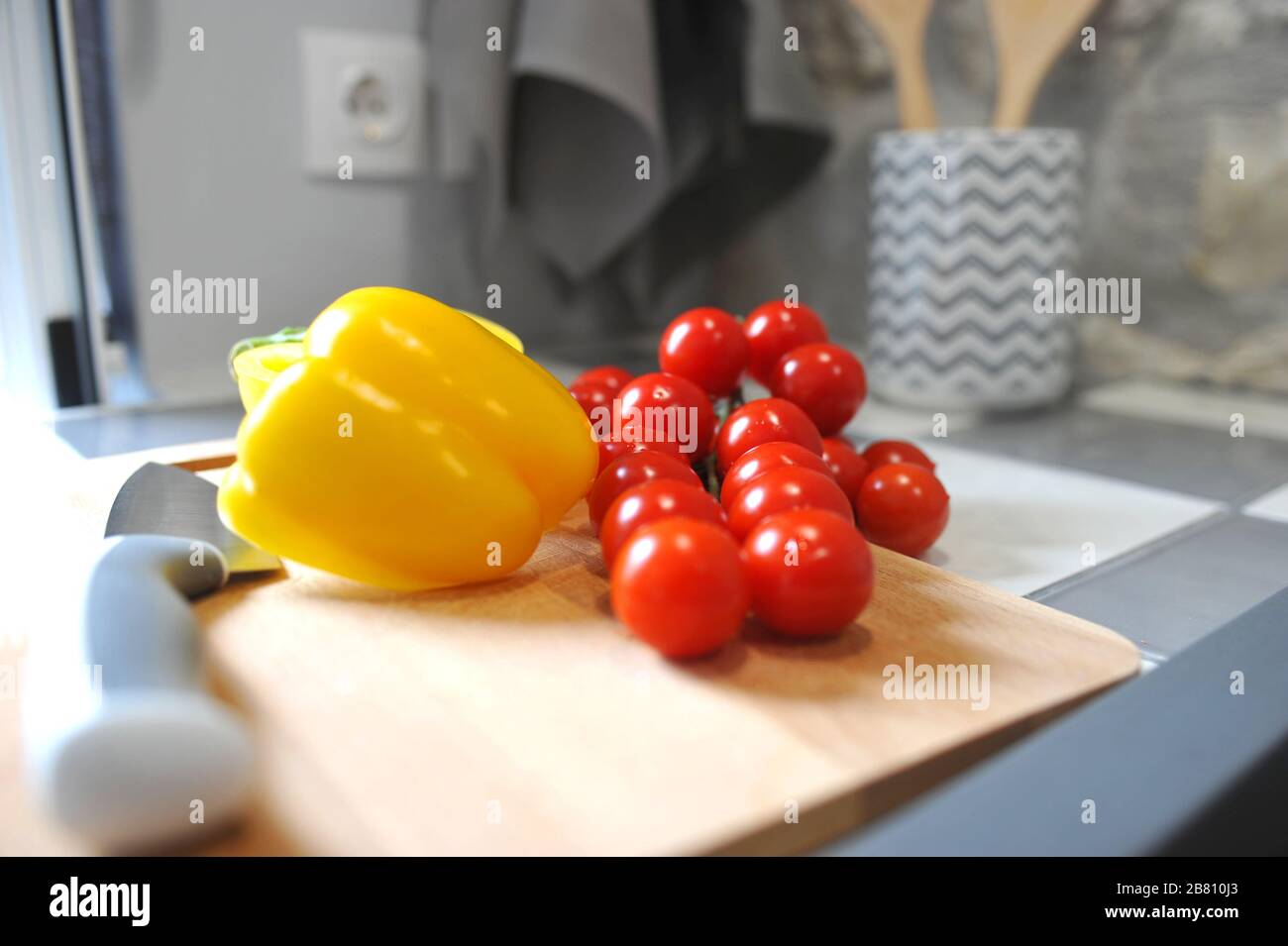 Cherry tomatoes and peppers on cutting board. Stock Photo