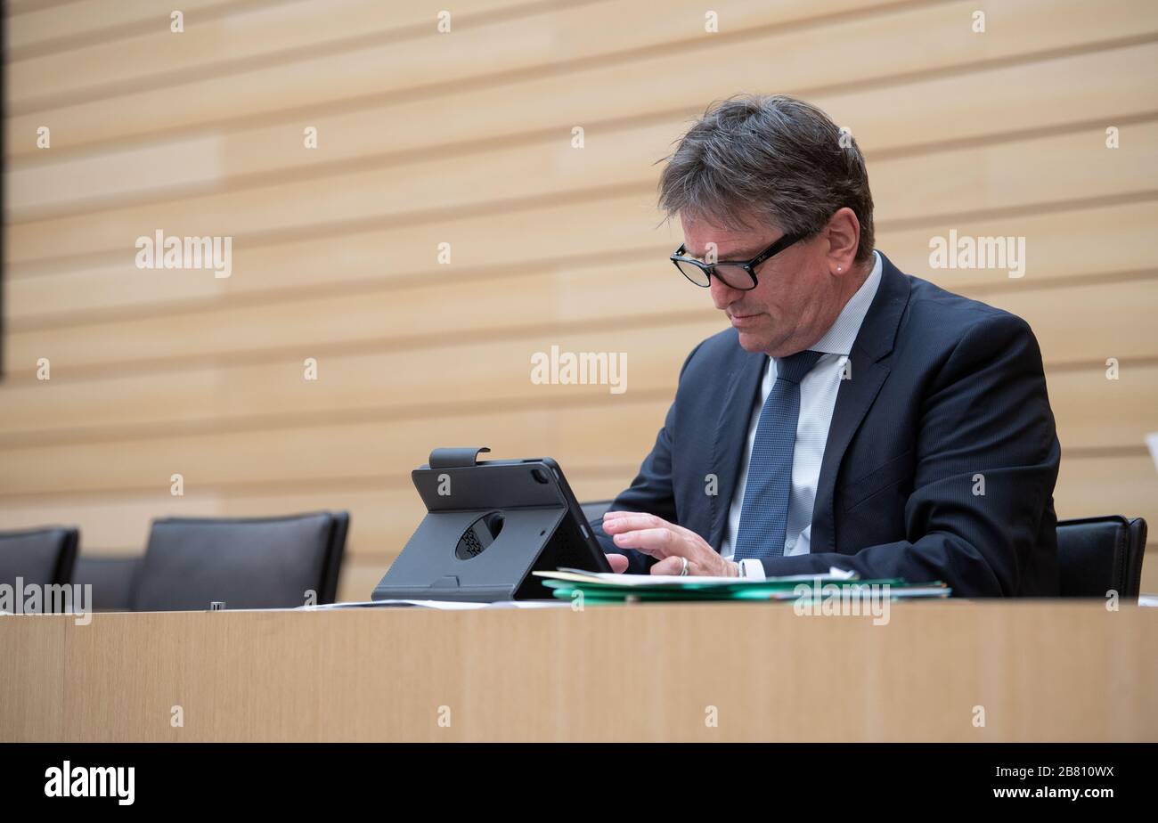 Stuttgart, Germany. 19th Mar, 2020. 19 March 2020, Baden-Wuerttemberg, Stuttgart: Manfred 'Manne' Lucha, Minister of Social Affairs of Baden-Württemberg, takes part in a plenary session of the state parliament of Baden-Württemberg. The state parliament met for a special session to set the course for the fight against coronavirus. During the session, the members of parliament should keep the recommended distance of 1.5 to 2 meters so that they do not infect each other in case a politician should be infected with the virus. Some Members should therefore take their seats in the public gallery of  Stock Photo