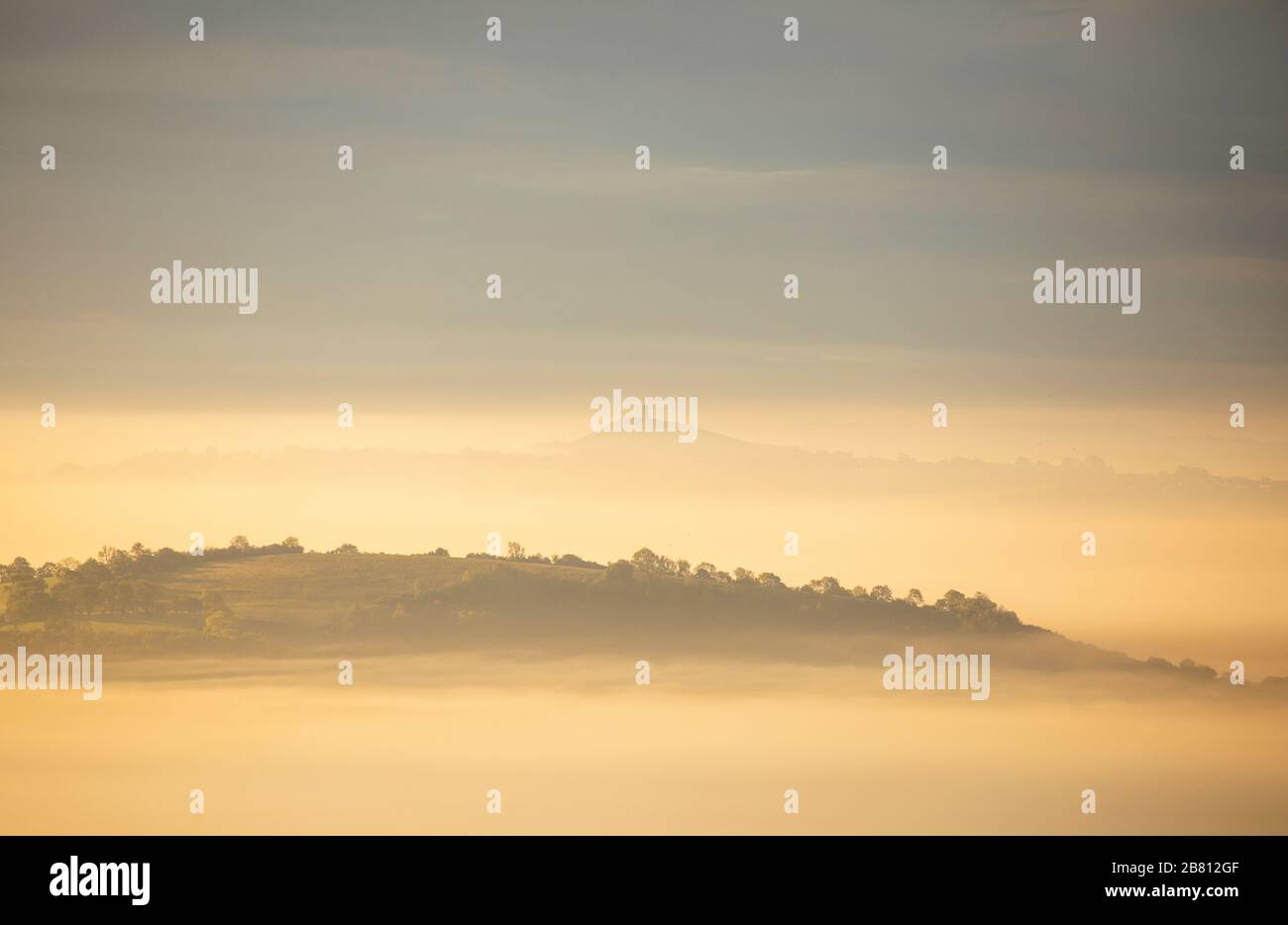 The sun rises over the Somerset levels with Glastonbury Tor in the background. Stock Photo