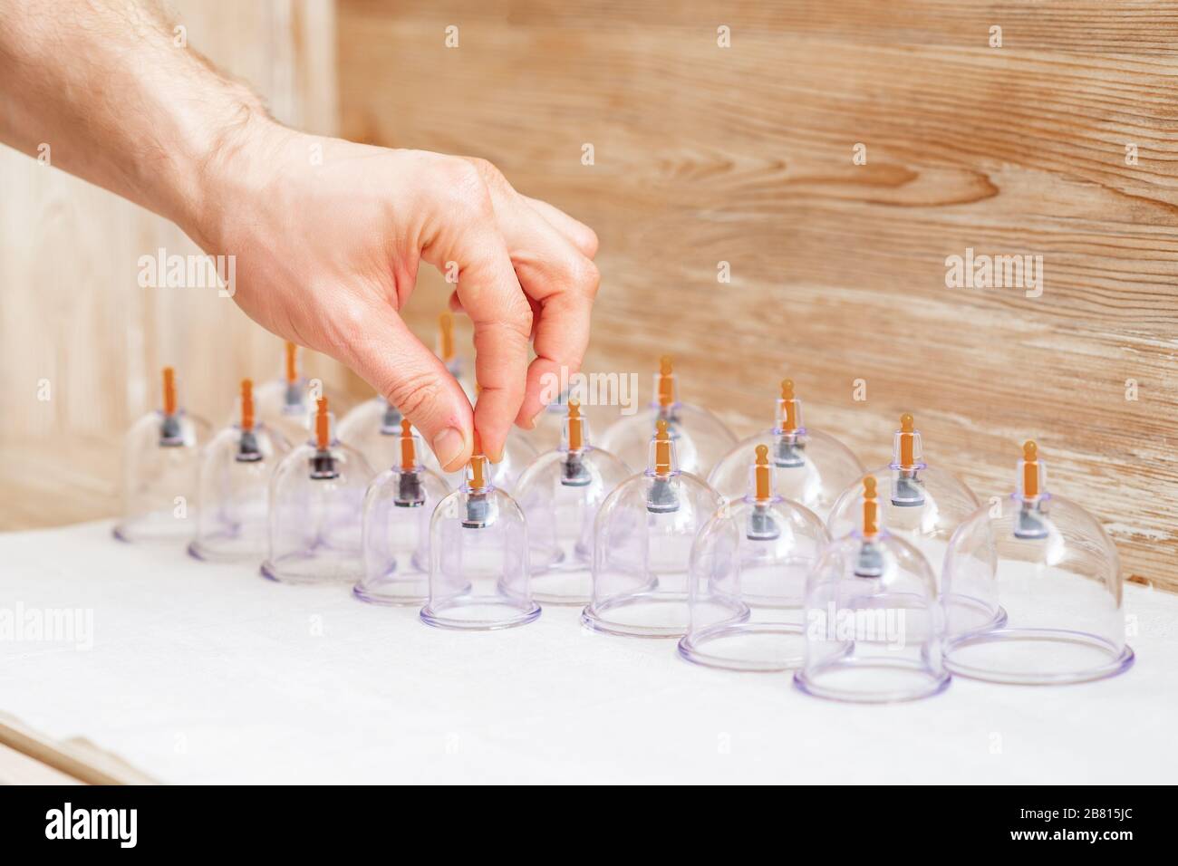 Hand takes vacuum massage glass jar from medical set of traditional