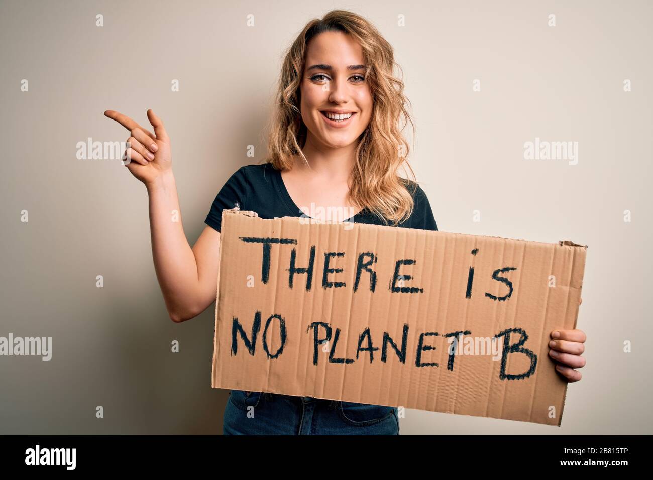 Young blonde activist woman asking for environment holding banner with ...