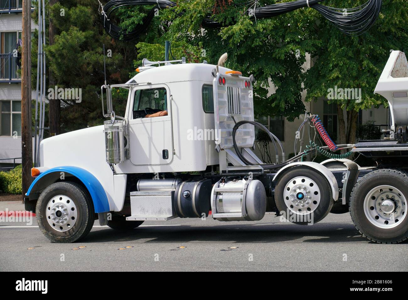 Side Dump trailer truck. A large vehicle in city traffic. Stock Photo
