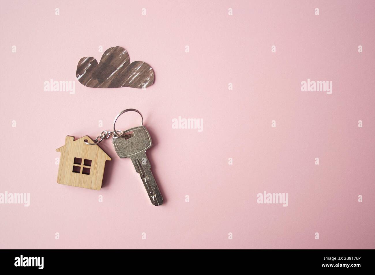 Paper dark cloud above the wooden house and key. Bad times, mortgage, no money concept. Flat lay. Top view Stock Photo