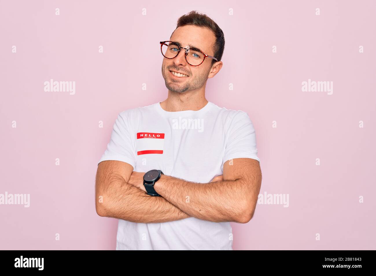 Handsome man with blue eyes wearing sticker with hello my name is ...