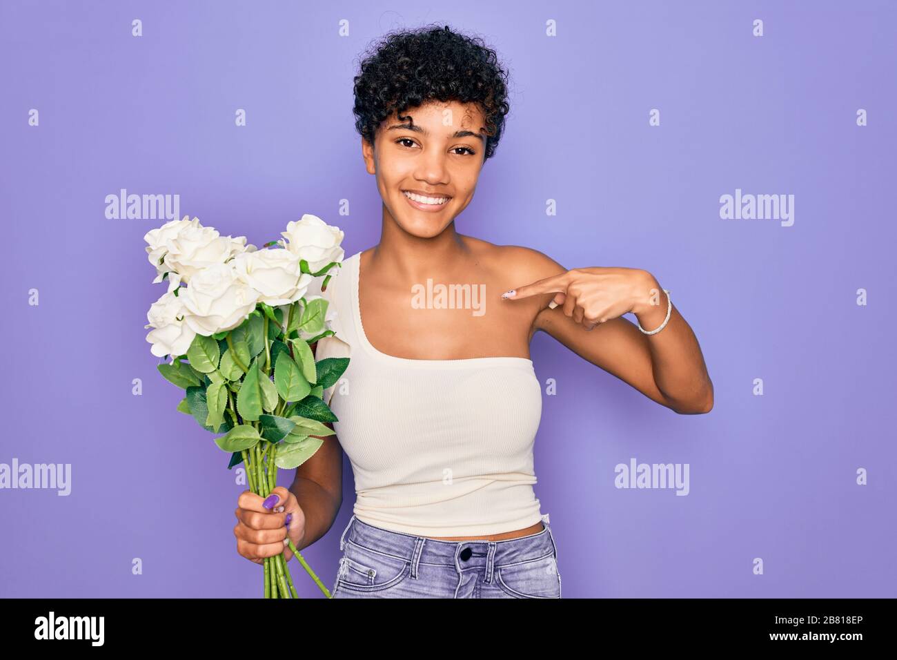 Beautiful african american afro woman holding bouquet of white flowers ...