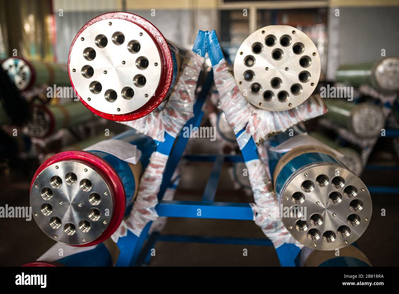 Close-ups the ends of large metal pipes lie at the factory on racks ...
