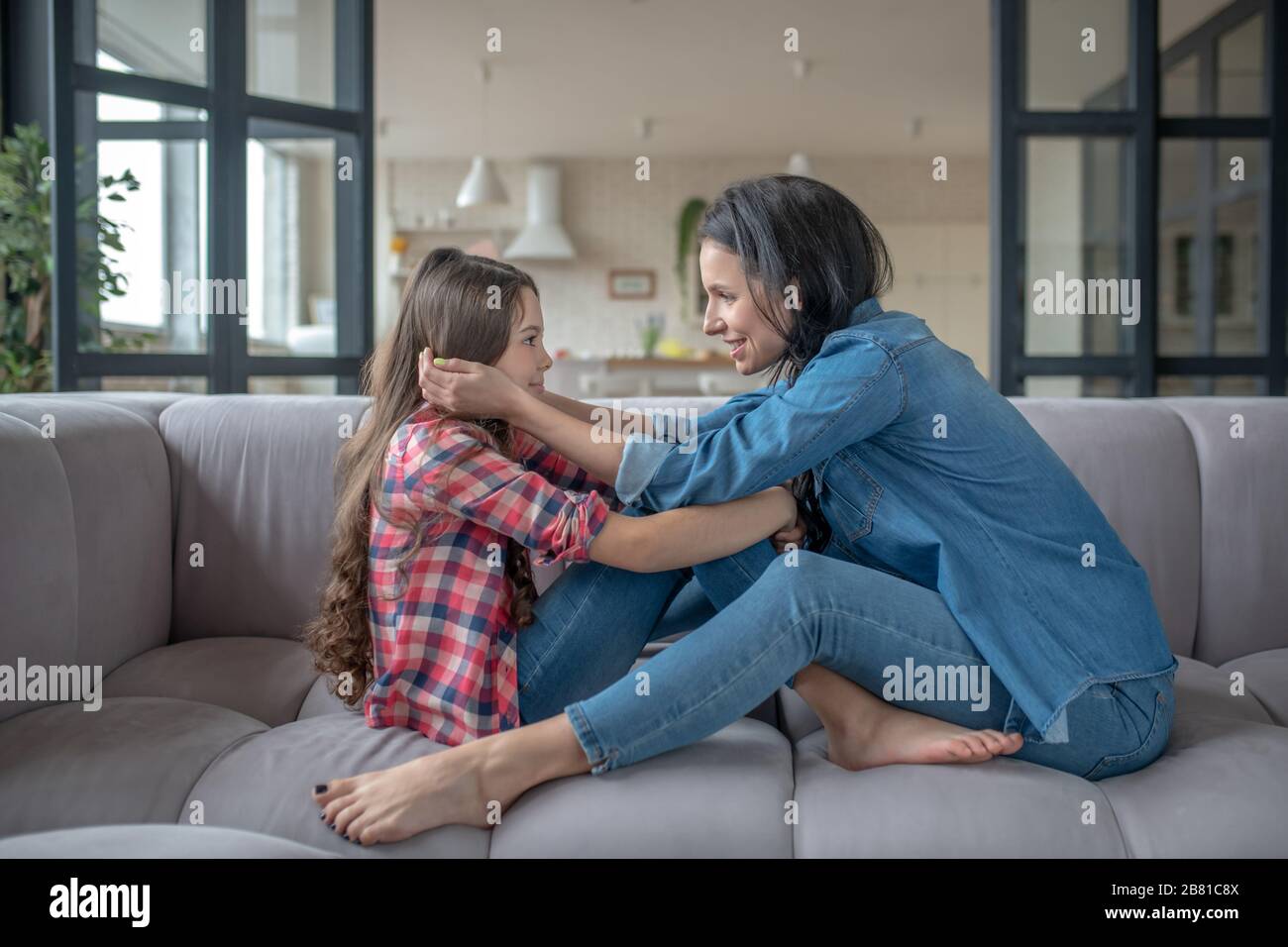 Mom touching her daughters face with care Stock Photo Alamy
