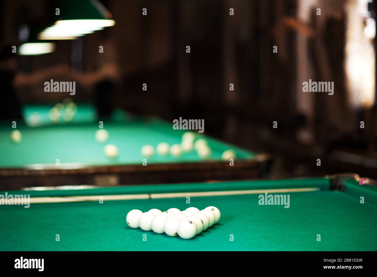 Table with green cloth, cue and balls for billiards. Photo of billiard