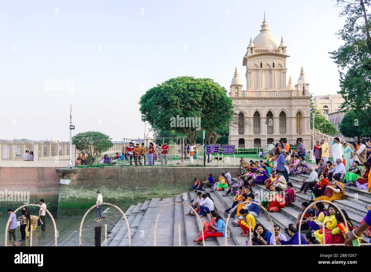 Large group of tourists people sitting on the steps and staircases that lies on the west bank of Hooghly River. Beluṛ Maṭh Ramakrishna Swami Vivekanan Stock Photo