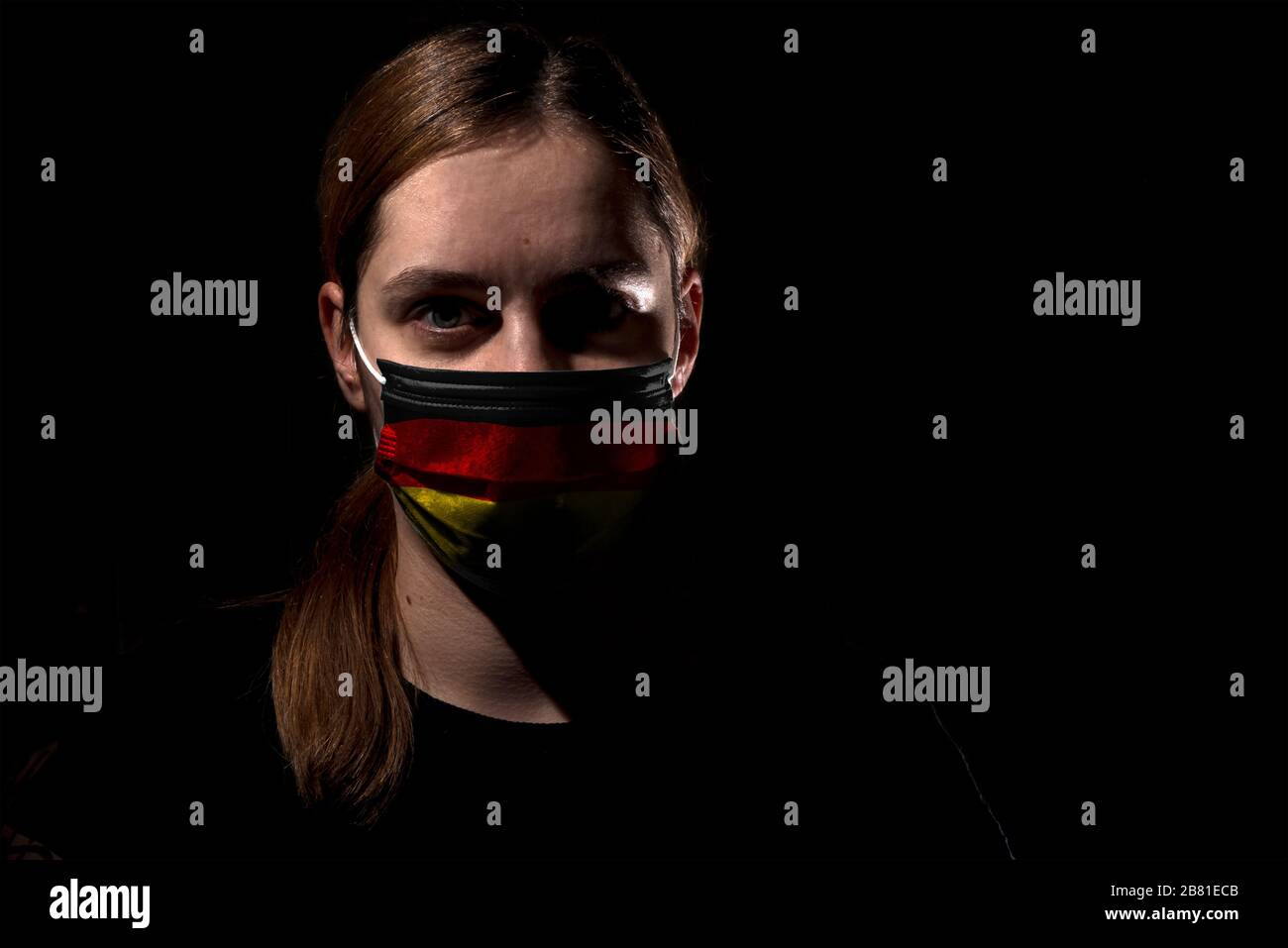 Woman wearing mask with Germany flag for protection of corona virus covid-19 SARS-CoV-2, woman with mask on black background Stock Photo