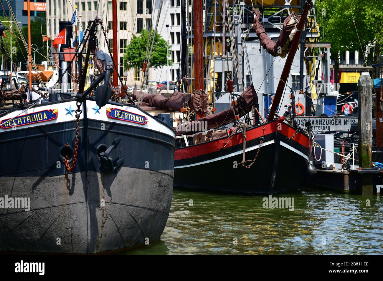 Rotterdam, The Netherlands - June 2019; close up view of a number of historic river barges moored in the Oudehaven in Rotterdam with modern high rise Stock Photo