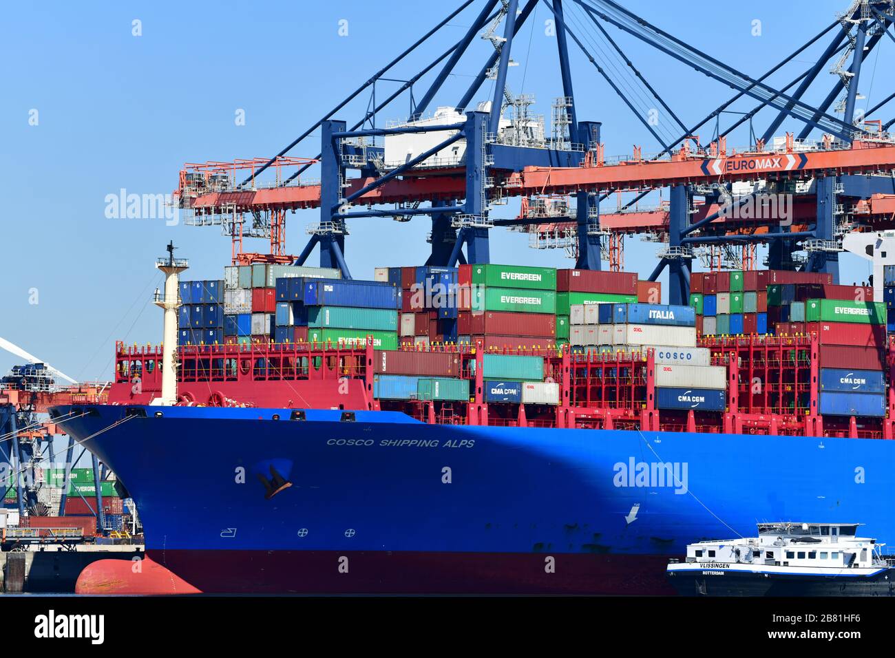 Rotterdam, The Netherlands - August 2019; close up of stern section of container ship,  handling ‘ship to shore’  logistics with gantry cranes rising Stock Photo