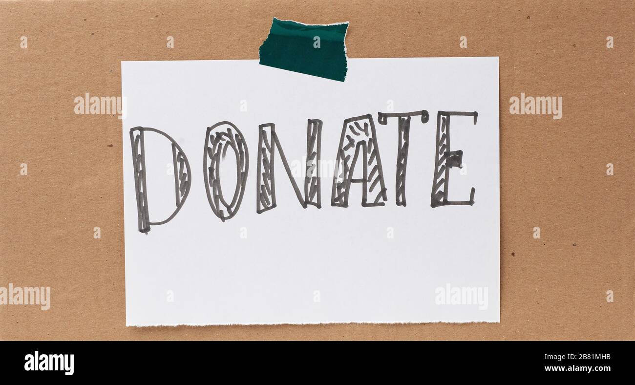 inscription donate on a white sheet and glued brown cardboard paper