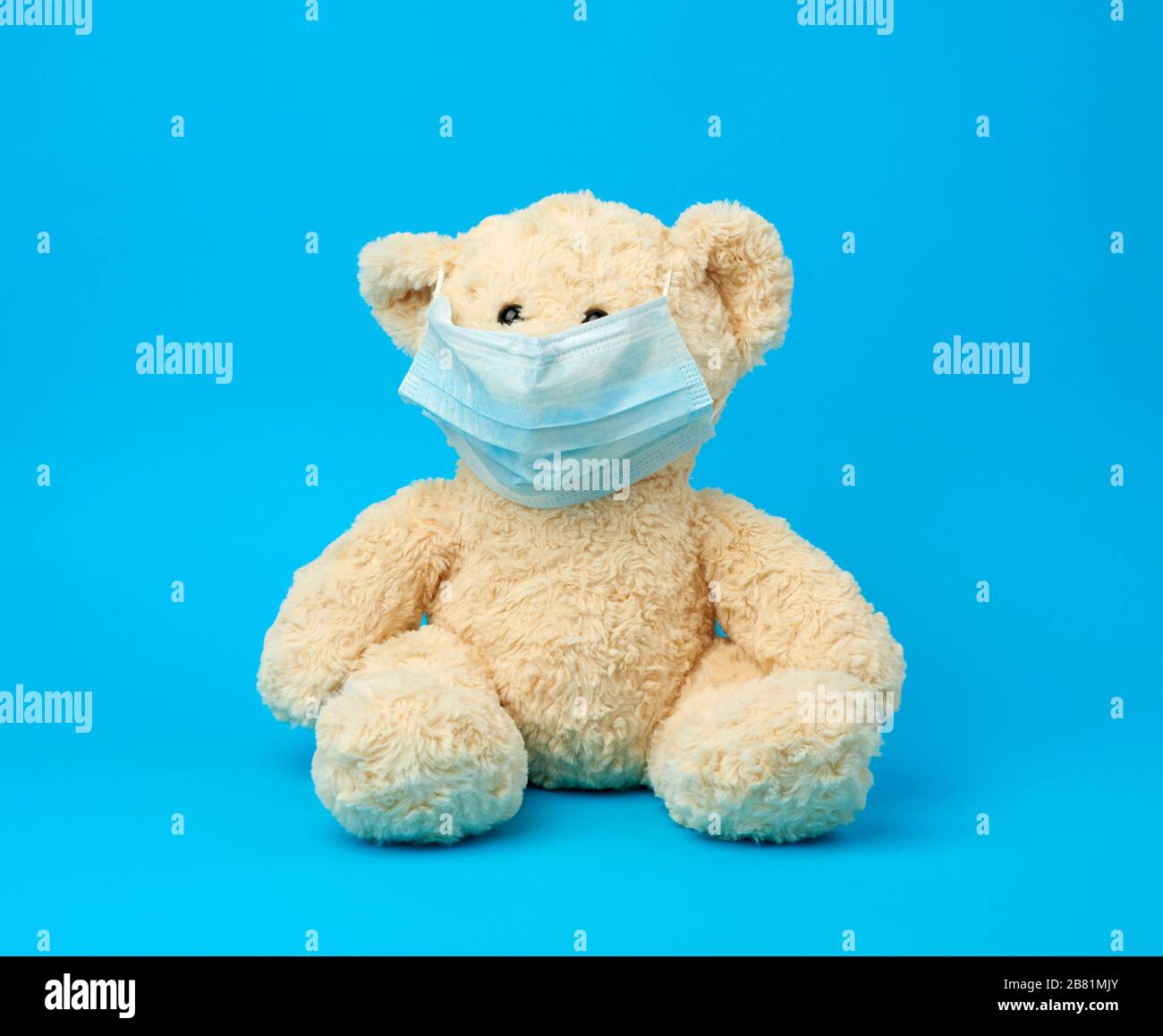 big teddy bear are sitting in medical masks on a blue background, concept of protection from respiratory disease, virus and individual respiratory pro Stock Photo