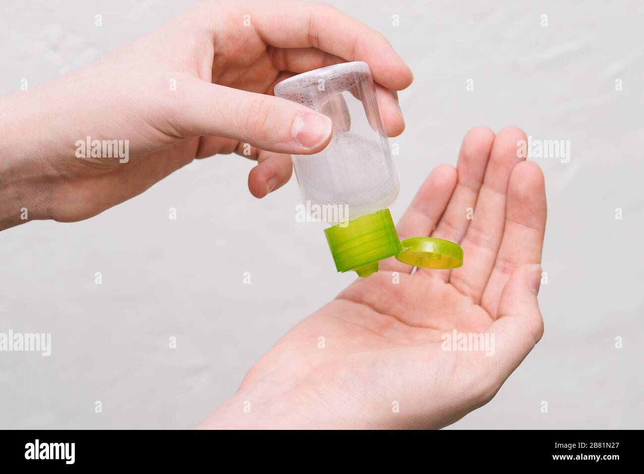 Hand antiseptic. Girl squeezing sand sanitizer on hands from a bottle