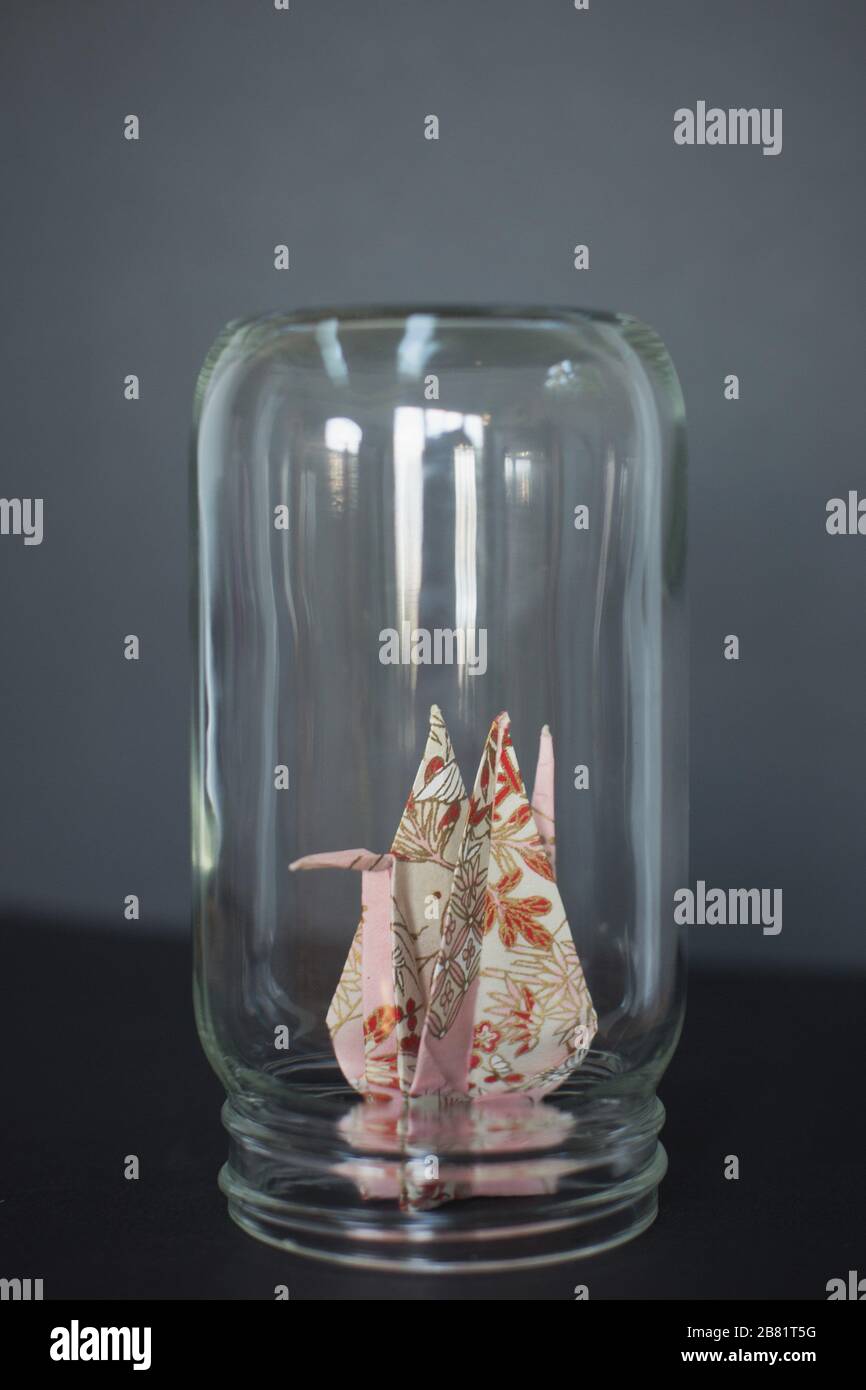 An origami crane trapped in a glass jar Stock Photo Alamy