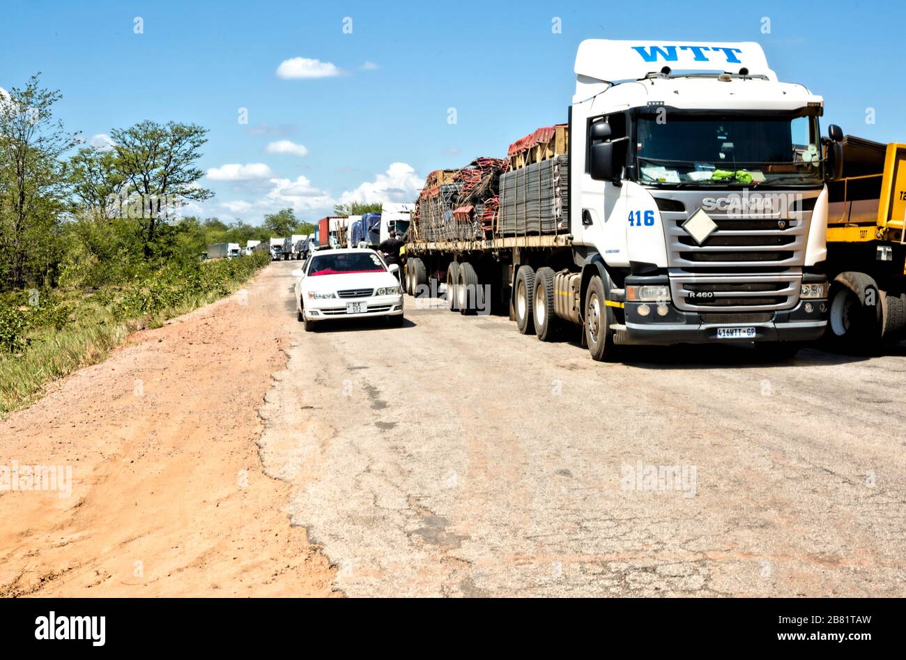 A line of trucks stands motionless, stretching back for miles as drivers wait to cross the border post at Chirundu from Zimbabwe into Zambia. Stock Photo