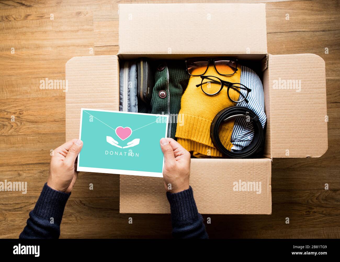 Donation concepts with person holding direct mail card on accessories clothing in box.giving and sharing with human.second hand or recycle Stock Photo