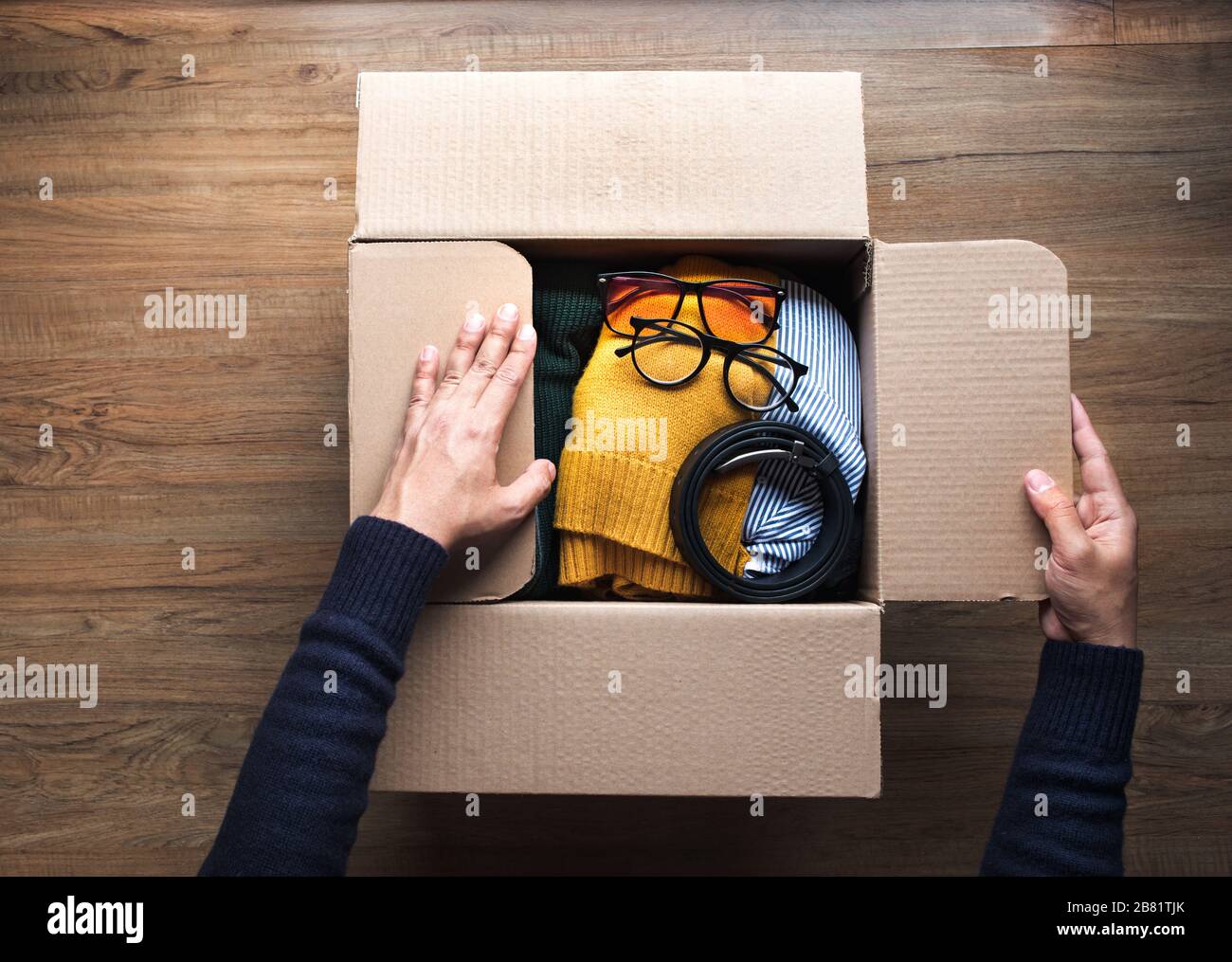 Donation concepts with young person packing accessories clothing in ...