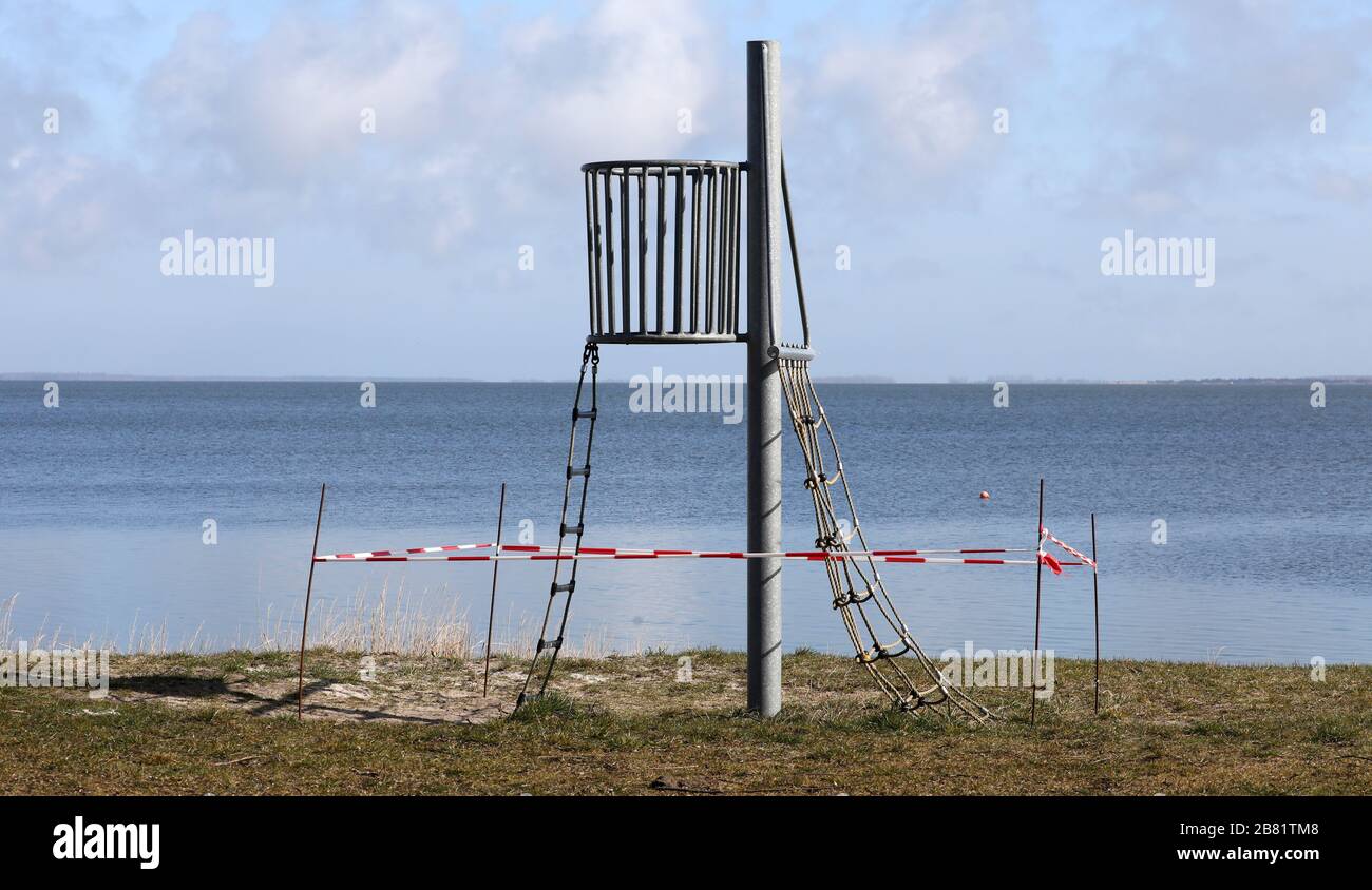 Prerow, Germany. 19th Mar, 2020. A small climbing frame at the Bodden is closed off with a red and white fluttering band. To slow down the spread of the corona virus, people are asked to avoid social contact. Credit: Bernd Wüstneck/dpa-Zentralbild/dpa/Alamy Live News Stock Photo