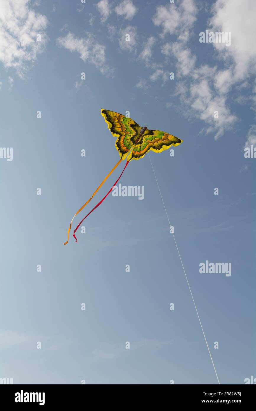 Kite flying against a blue sky with clouds Stock Photo Alamy