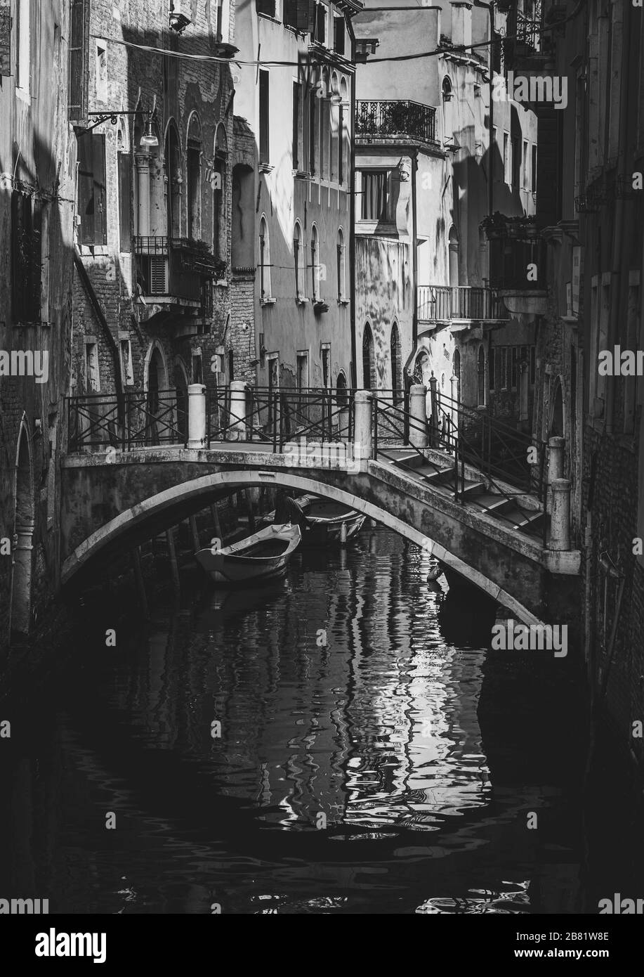 empty streets of Venice Italy with a bride reflecting in the water and the traditional houses and boats in the channels Stock Photo