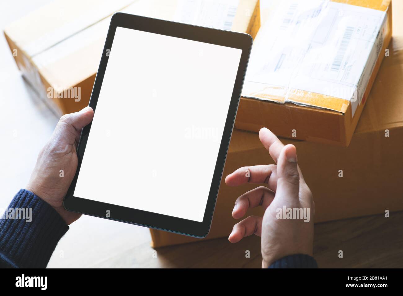 Online shopping concepts with youngman using tablet on product package box.Ecommerce market.Transportation logistic.Business retail.Seller and buyer Stock Photo