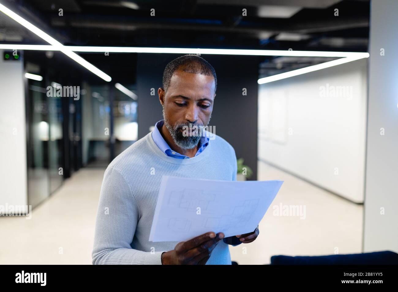 African American man reading papers in office Stock Photo