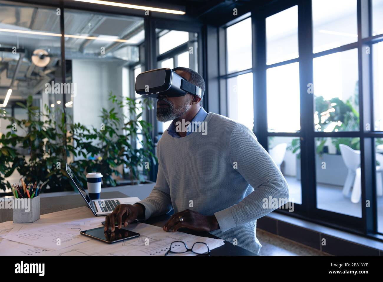 African American man using virtual reality in office Stock Photo
