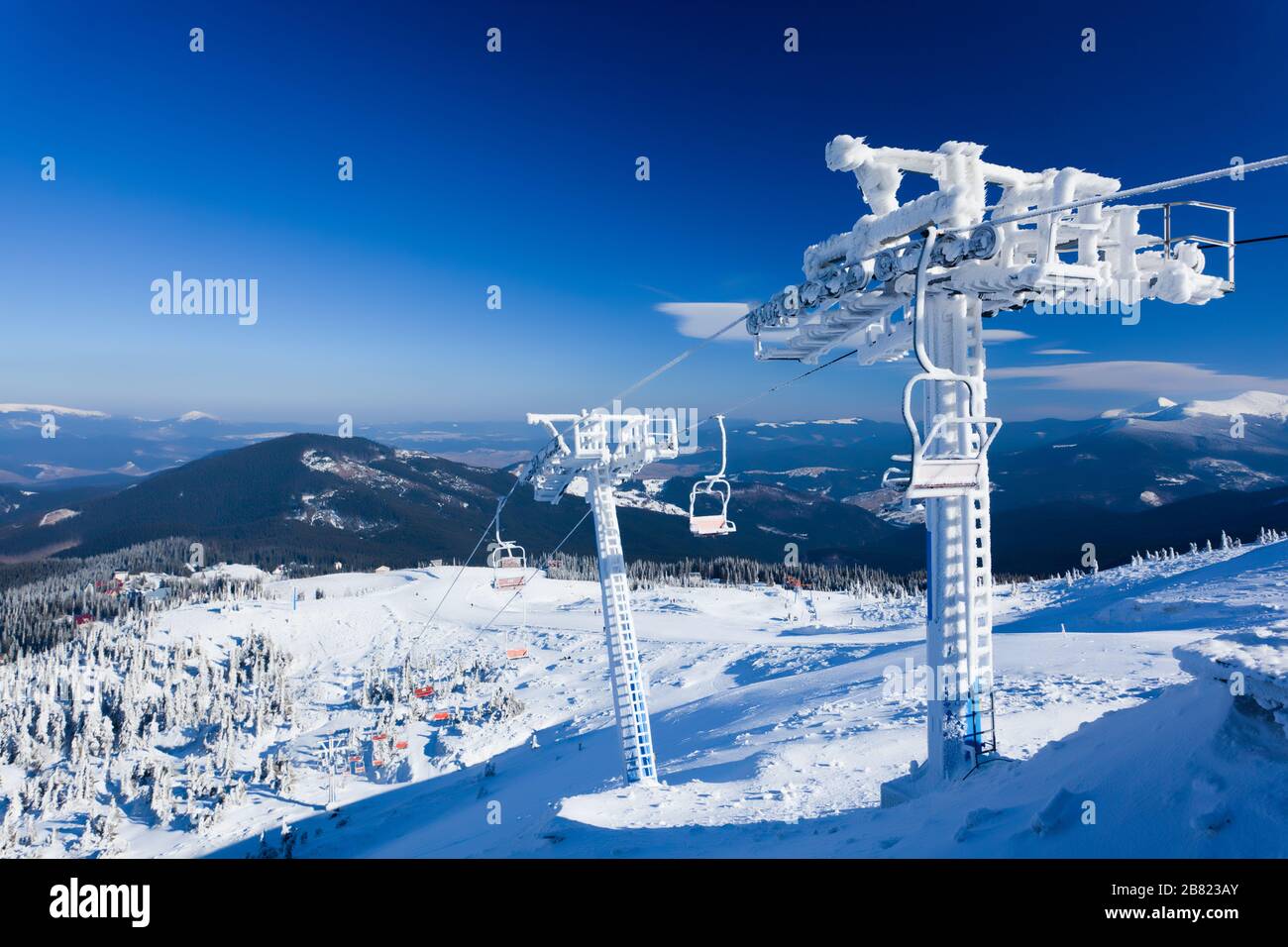 Empty ski lift covered with frost and snow with mountains at background on  sunny clear winter day with blue sky. Travelling and winter activities conc  Stock Photo - Alamy