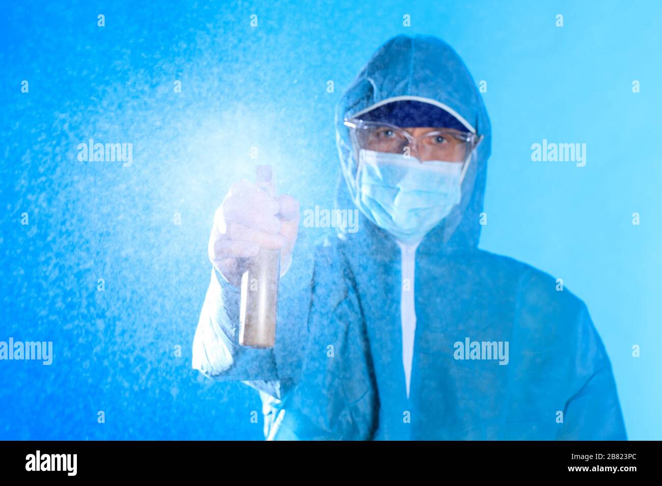 Man wearing protective biological suit and gas-mask due to mers coronavirus global pandemic warning and danger. Medic sphysician scientist make disinf Stock Photo