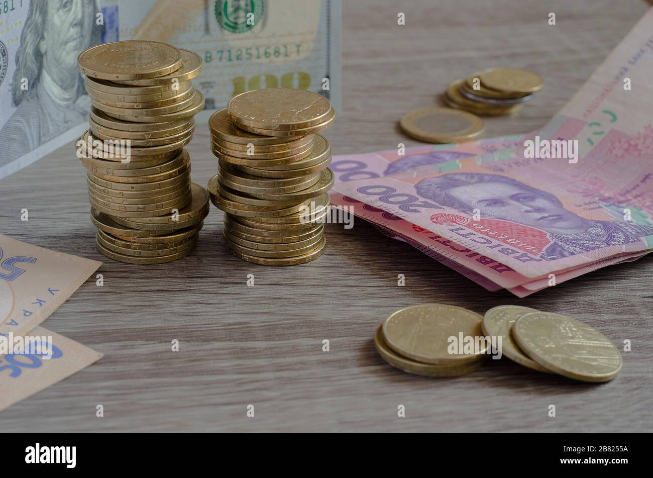 piles of coins Ukrainian hryvnia and US dollars Stock Photo