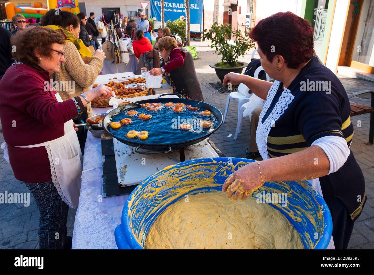 Spanish Ladies making Bunuelos Buñuelo in local village market Stock Photo