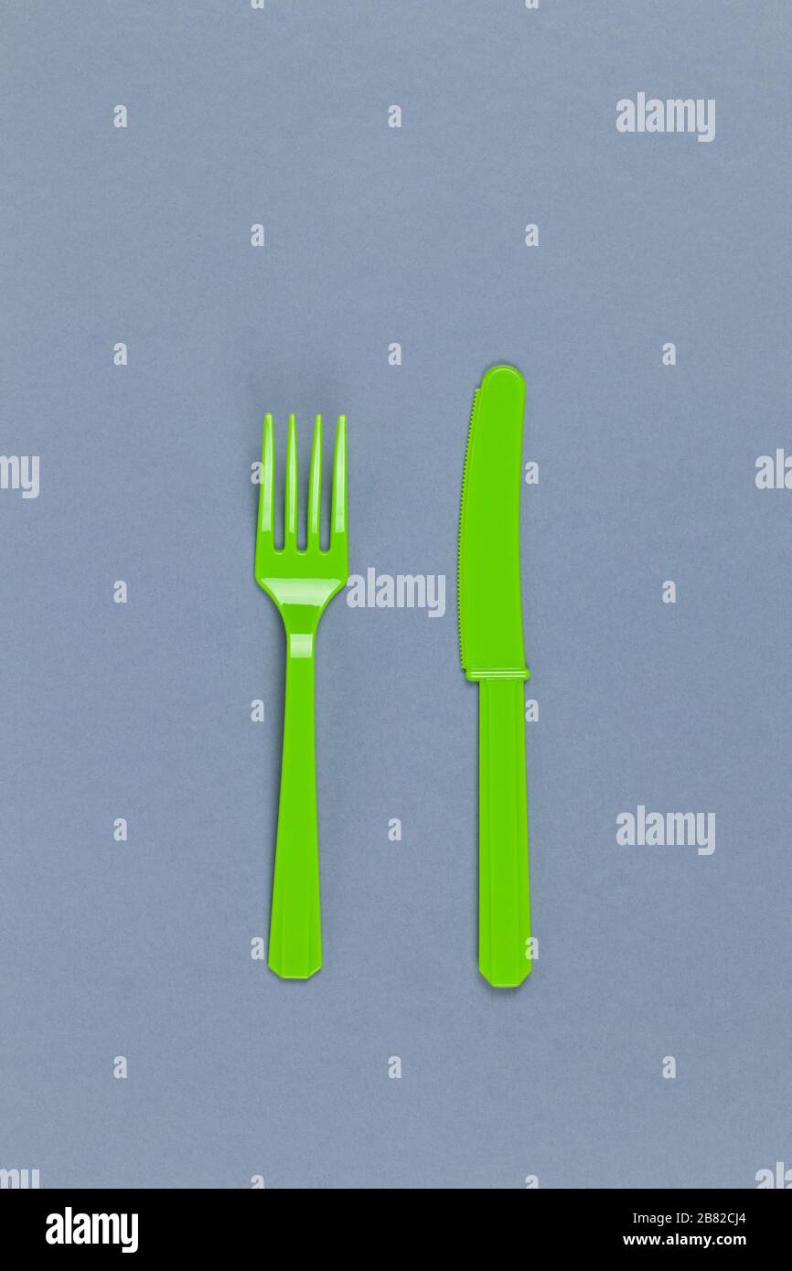 Reusable recyclable green fork, knife made from corn starch on grey