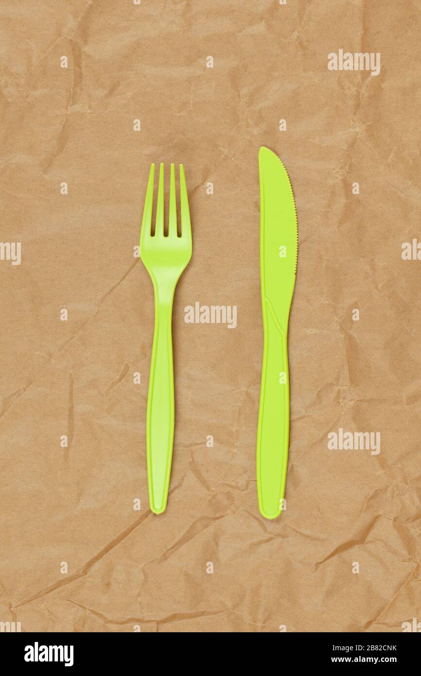 Reusable recyclable green fork, knife made from corn starch on brown