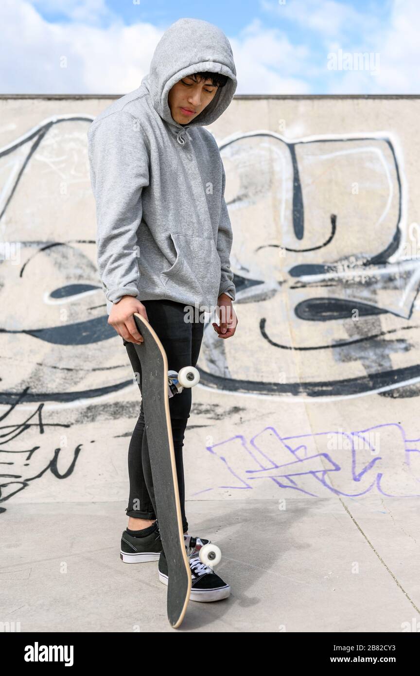 Young skater posing with skateboard at skate park Stock Photo - Alamy