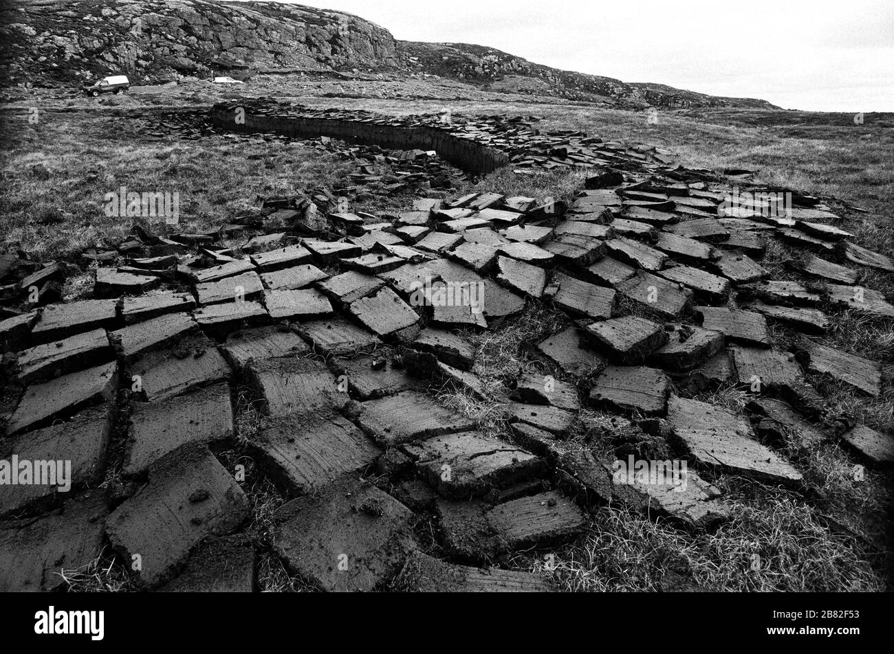 Freshly cut peat bogs on a stretch of land on the island of Lewis in the Outer Hebrides, Scotland. Peat cutting was a traditional method of gathering fuel for the winter in the sparsely-populated areas on Scotland's west coast and islands. The peat was dried and used in fires and ovens. Stock Photo
