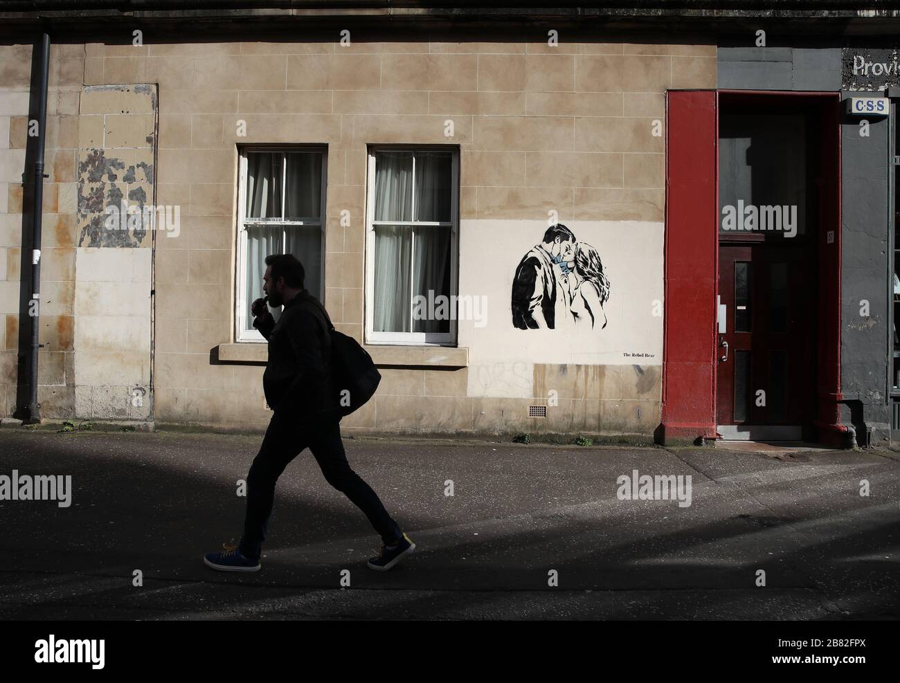 A piece of art by the artist, known as the Rebel Bear has appeared on a wall on Bank Street in Glasgow. The new addition to Glasgow's street art is capturing the global Coronavirus crisis. The piece features a woman and a man pulling back to give each other a kiss. Stock Photo