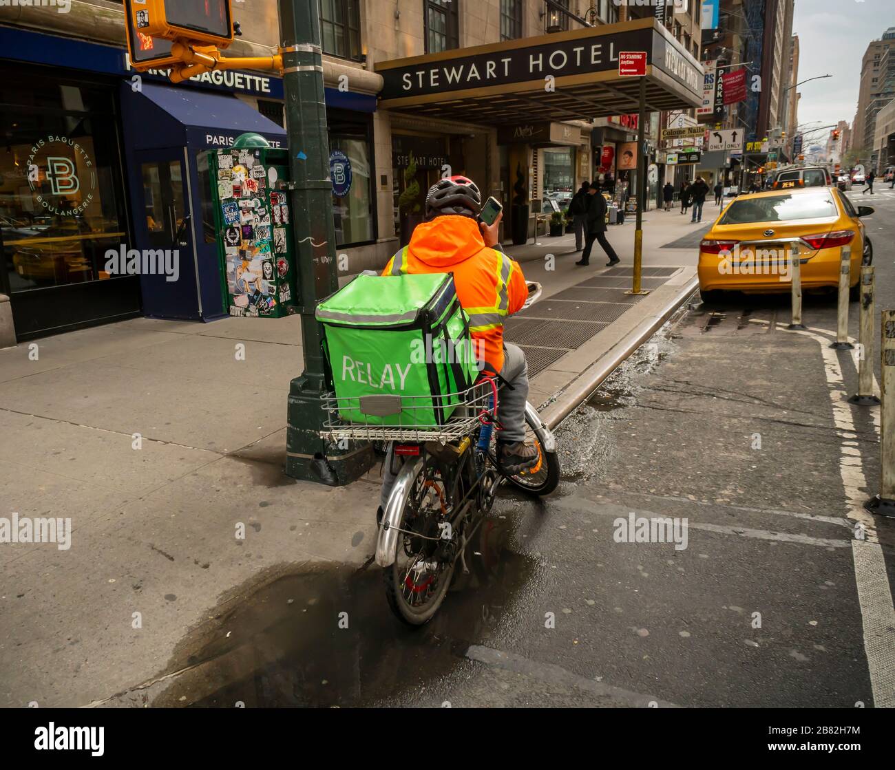 A deliveryman from Relay waits for his next pick-up order in New York on Tuesday, March 17, 2020. Due to the requirement of social distancing bars and restaurants are closing with restaurants allowed to only do take-out and delivery. (© Richard B. Levine) Stock Photo