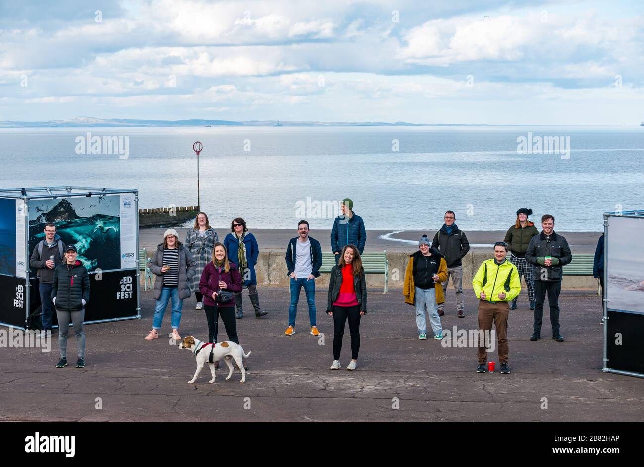 Portobello promenade, Edinburgh, Scotland, United Kingdom. 19th March 2020. Edinburgh Science Festival: the only event in the now cancelled programme due to Covid-19 Coronavirus pandemic is an open air exhibition called 'Into the Blue' with photographs in celebration of Scotland's Year of Coasts and Waters. The Science Festival team practice social distancing Stock Photo