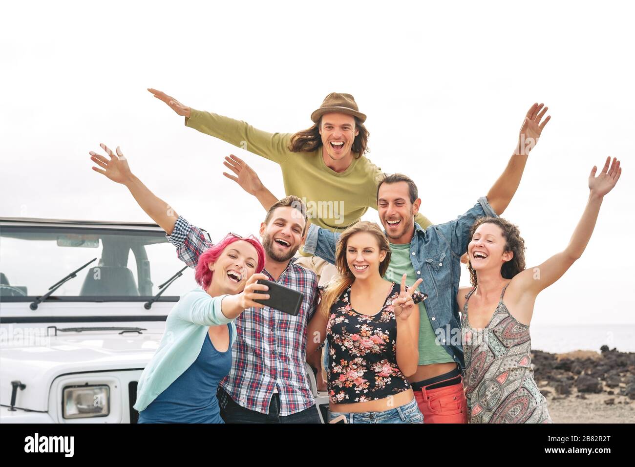 Group young friends taking selfie with mobile smartphones during road trip - Happy travel people having fun in vacation Stock Photo