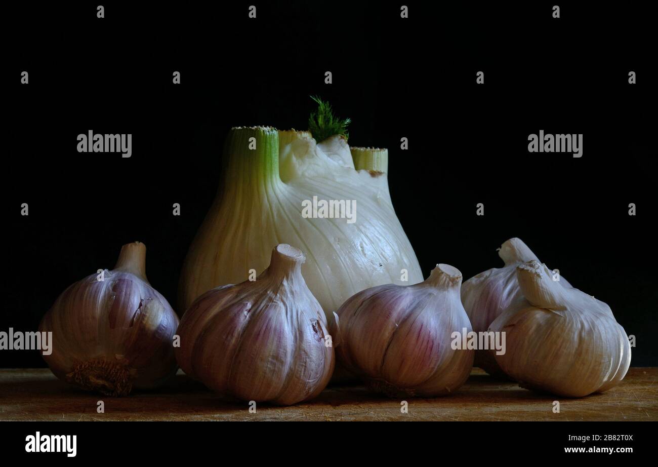 pink garlic cloves and fennel bulb on black background Stock Photo