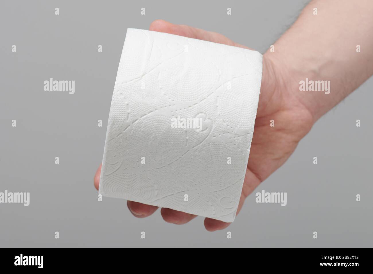 New soft roll of toilet paper in hand close up view Stock Photo