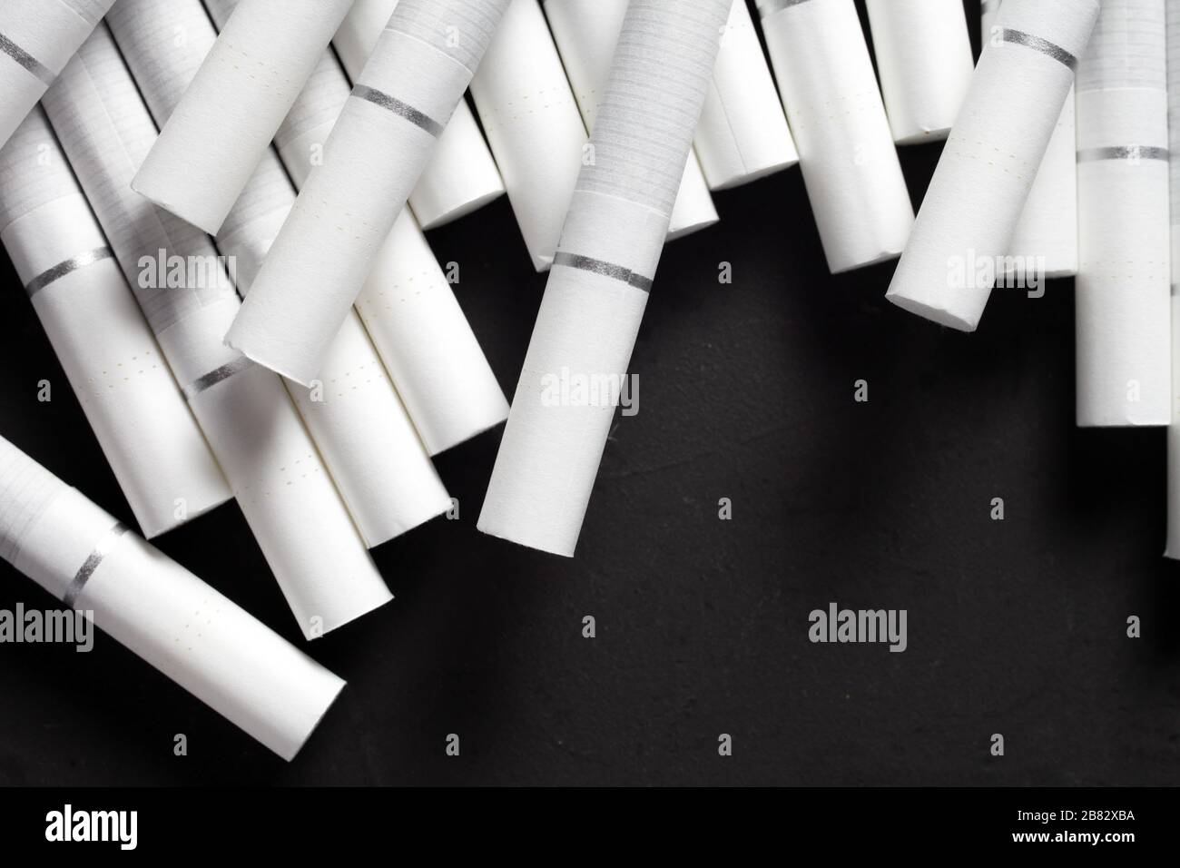 why are some cigarette filters white Cigarettes with a white filter on a dark concrete background Stock Photo
