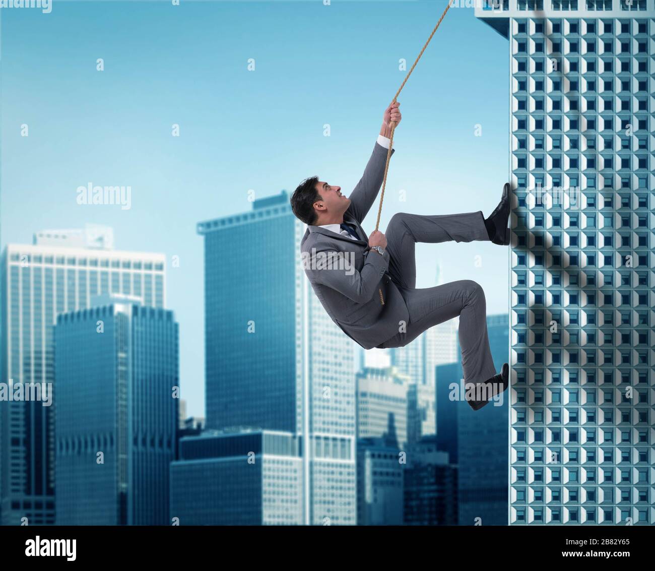 The businessman in challenge concept climbing skyscraper Stock Photo