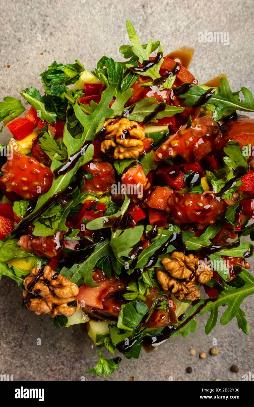Vegetable salad with arugula, tomatoes, avocado, splashed with balsamic sauce. Top view. Macro. Stock Photo