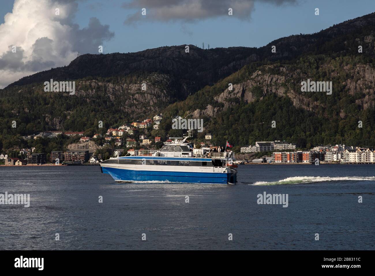 Sightseeing catamaran Hardangerprins departing the port of Bergen, Norway. Passing Sandviken Stock Photo