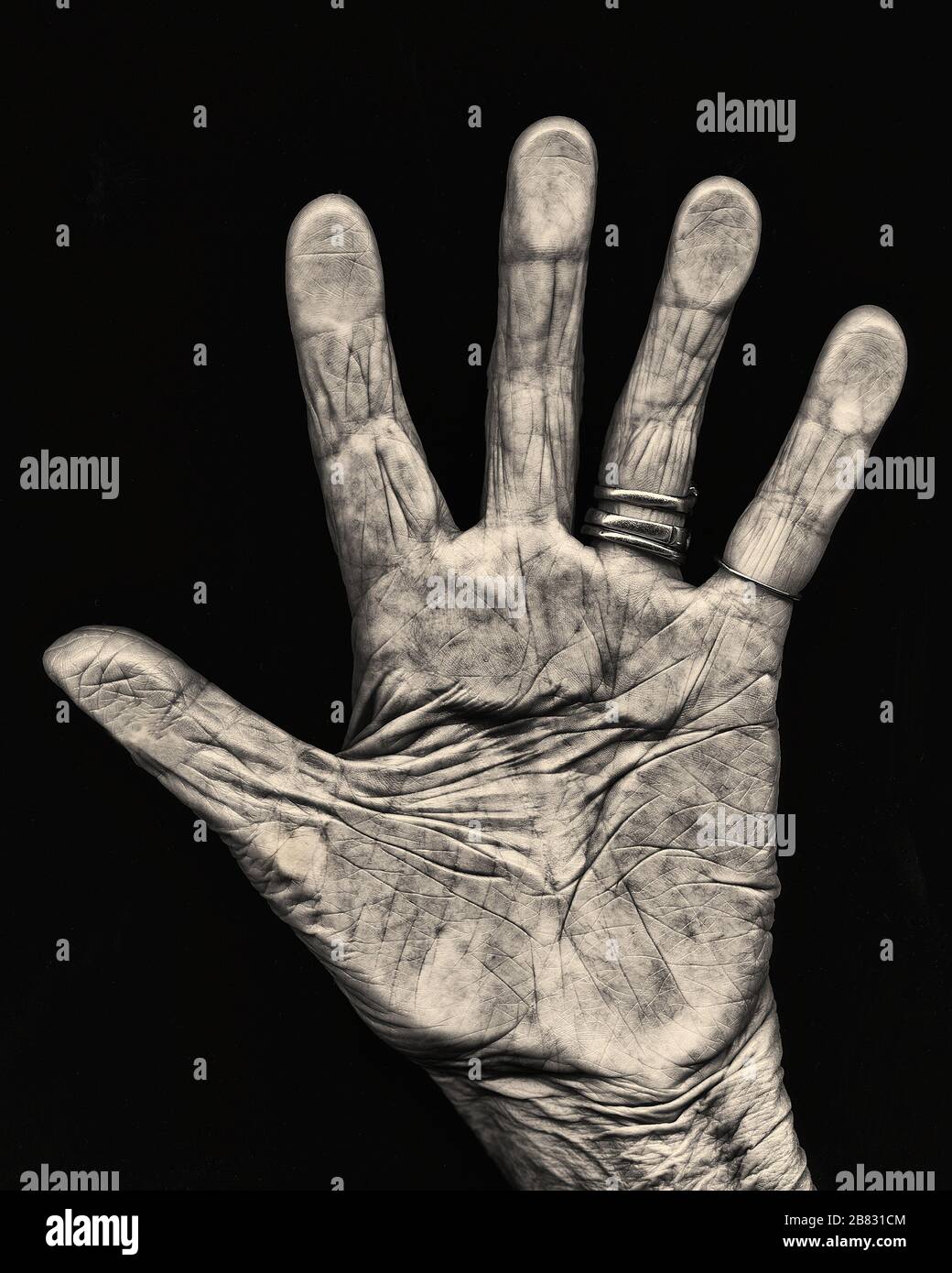 Elderly Hand against Black Background, Open with Palm Facing Camera Stock Photo