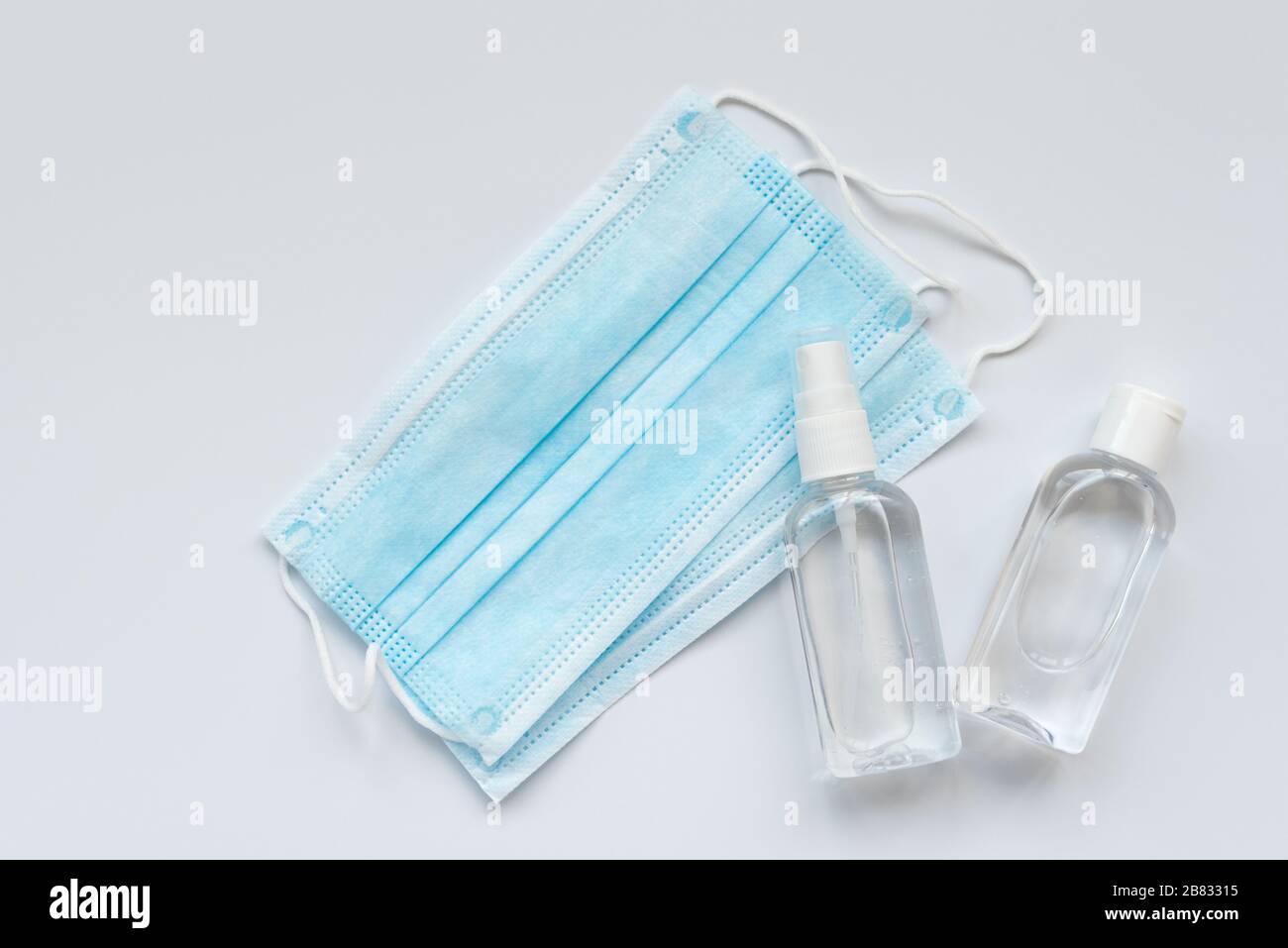Surgical medical face mask, bottles of antiseptic hand gel and spray on ...