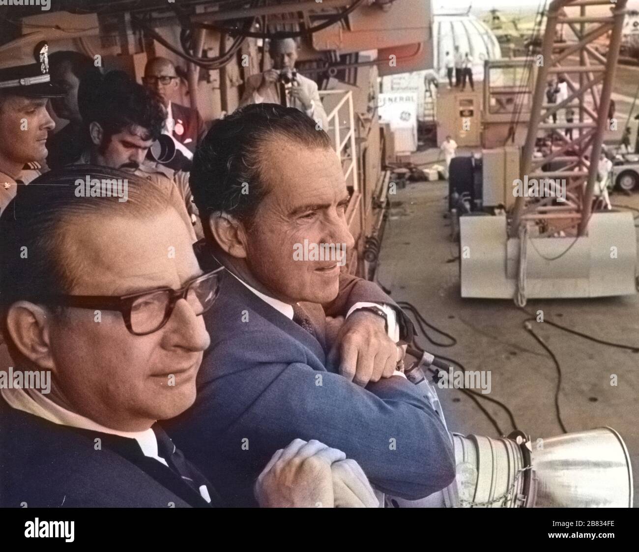President Richard M. Nixon and NASA Administrator Dr Thomas O. Paine watching Apollo 11 astronauts walk from the recovery helicopter to the Mobile Quarantine Facility aboard the U.S.S, July 24, 1969. Hornet. Image courtesy National Aeronautics and Space Administration (NASA). Note: Image has been digitally colorized using a modern process. Colors may not be period-accurate. () Stock Photo